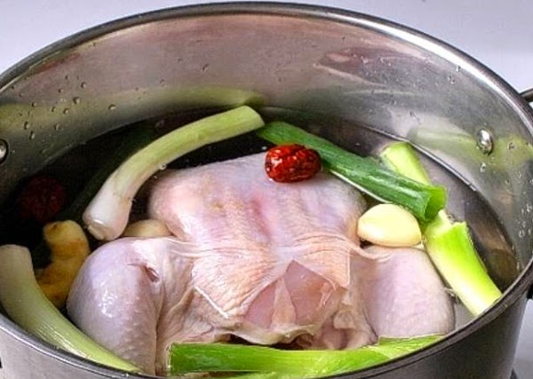  Cho con gà vào nồi và đổ ngập nướccho thêm hành khô, gừng và ngò vào và thêm vào một xíu muối.